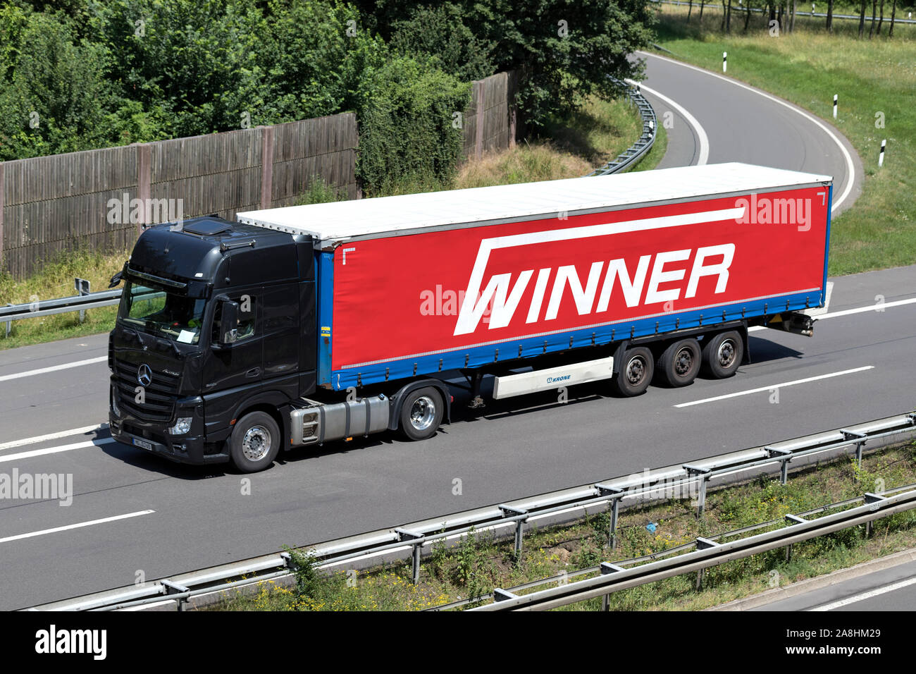 Mercedes-Benz Actros truck with Winner curtainside trailer on motorway. Stock Photo