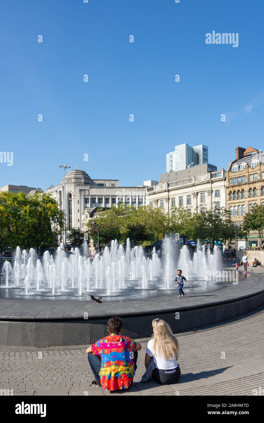 Couple sitting by fountain in Piccadilly Gardens, City Centre, Manchester, Greater Manchester, England, United Kingdom Stock Photo