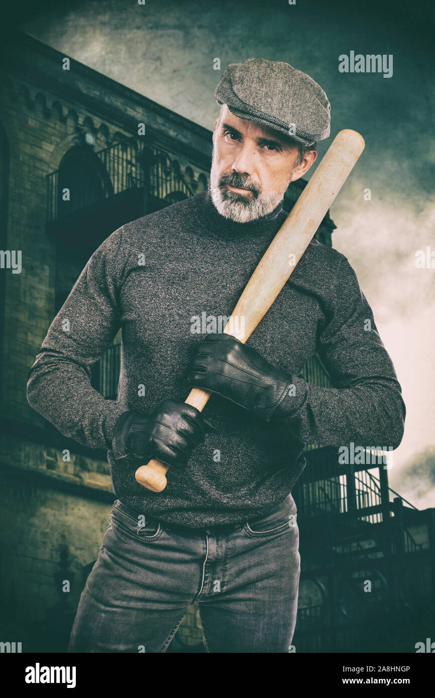 Gangster holding a baseball bat wearing leather gloves Stock Photo