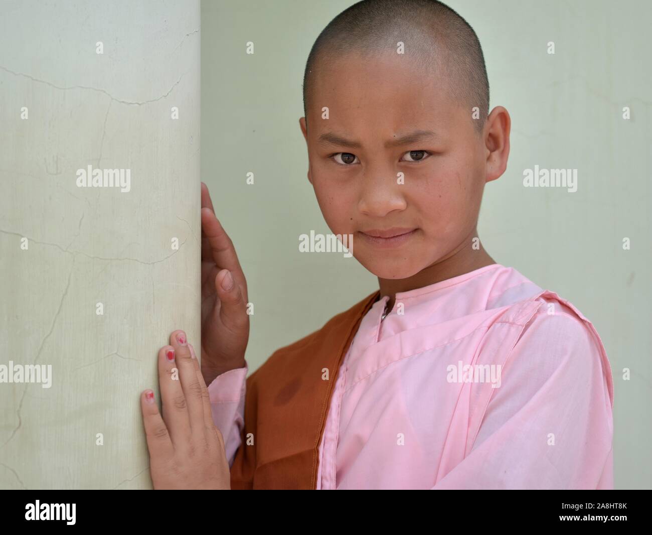 Burmese Buddhist teen girl nun (thilashin) poses for the camera. Stock Photo