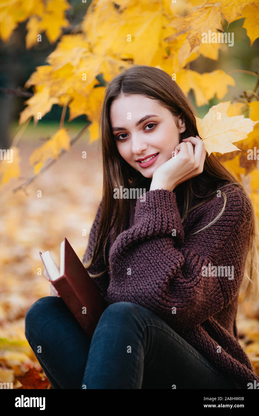 Beautiful girl in autumn forest reading a book Stock Photo - Alamy