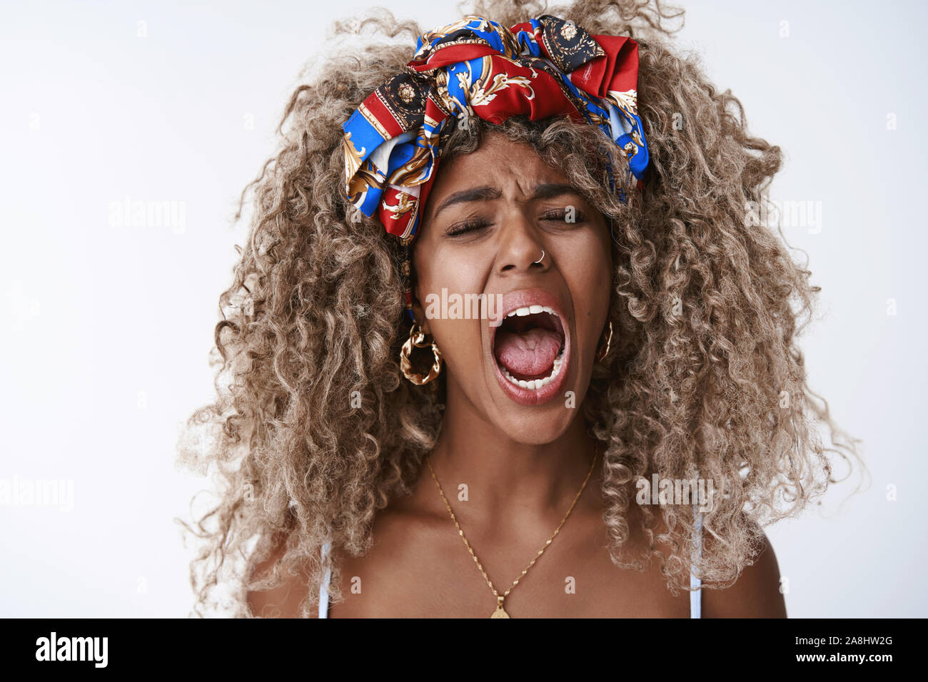 Close-up tired sleepy attractive african-american blond curly woman, afro  hairstyle in stylish hipster headband, piercing, yawning with closed eyes  Stock Photo - Alamy