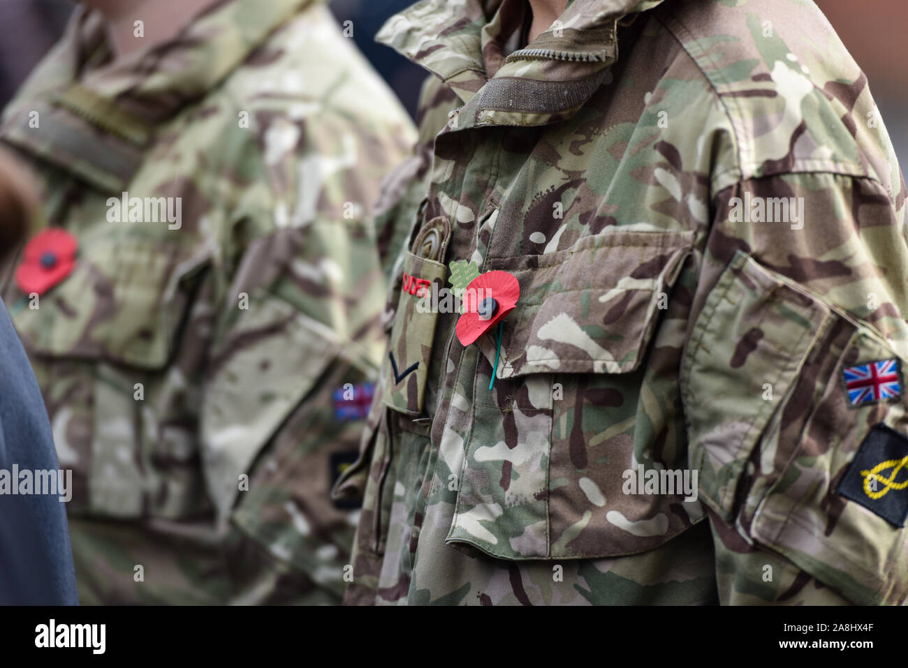 Army cadets stand in front of the war memorial wearing their poppies