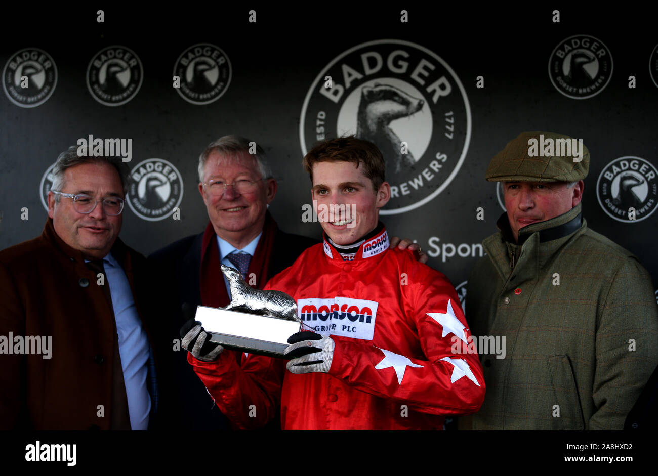 Harry Cobden poses with the trophy after winning the Badger Beers Silver Trophy Handicap Chase with Sir Alex Ferguson (second left) at Wincanton Racecourse. Stock Photo