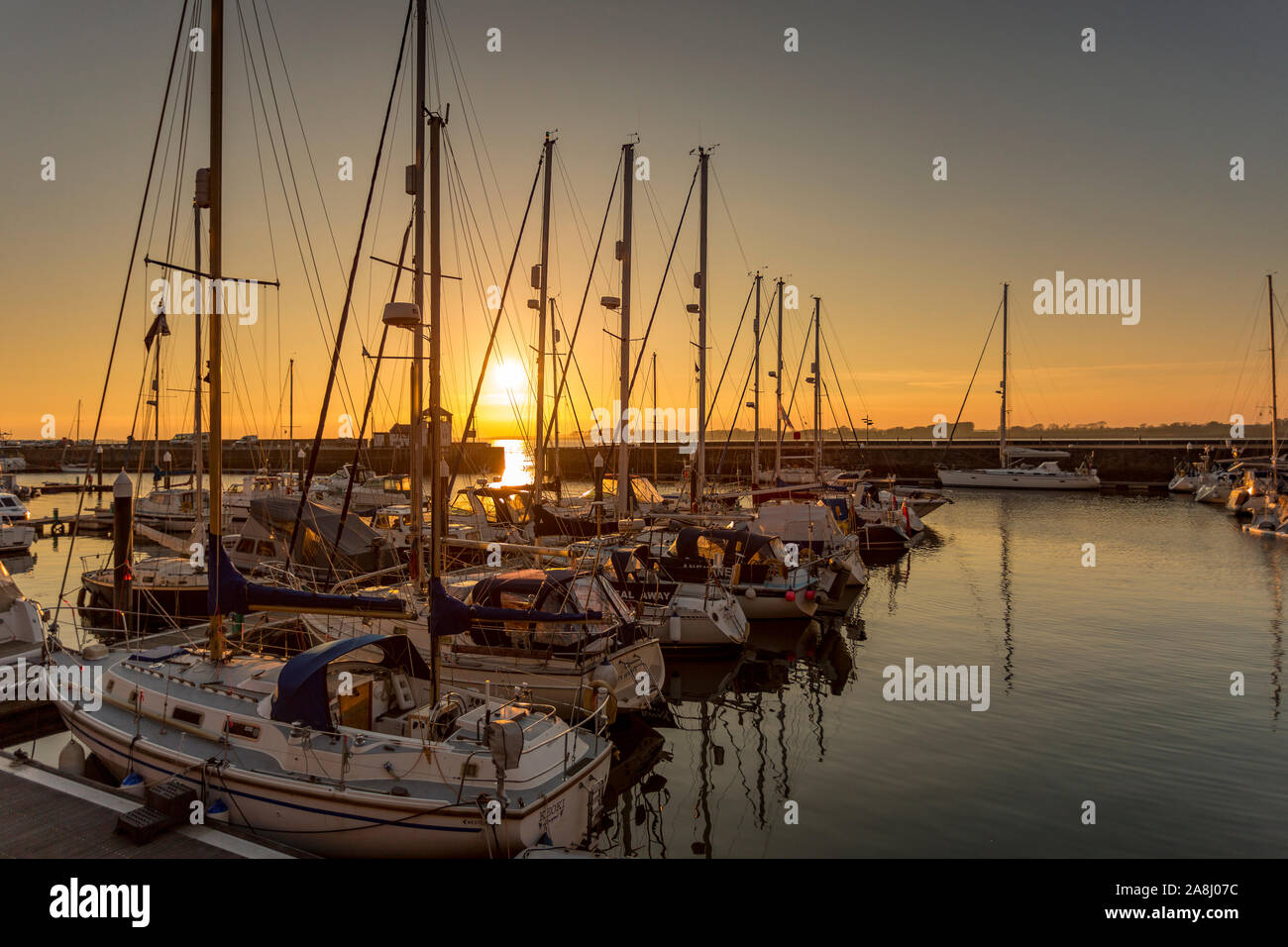 Yachts moored in the Victoria Dock at Caernarfon at sunset on the North Wales coast Stock Photo