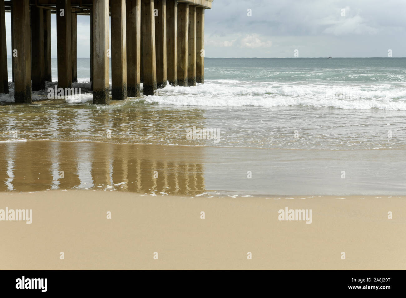 Durban, South Africa, background, reflection of concrete pillars on wet beach sand, jetty, architecture, landscape, seashore infrastructure, pier Stock Photo