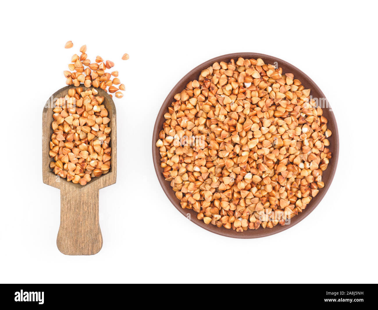 Buckwheat groats in clay plate and in wooden shovel on white background
