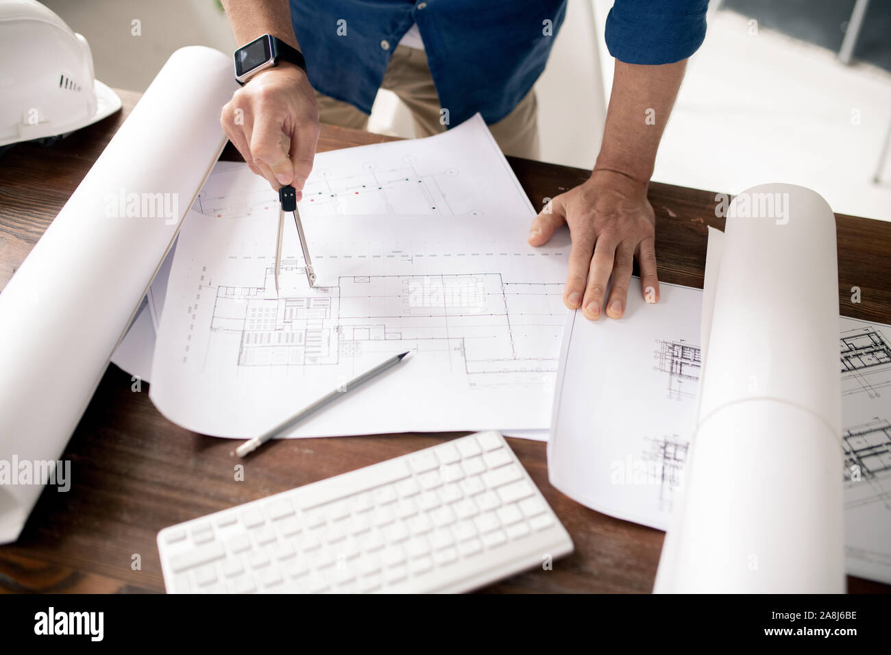 Contemporary architect with dividers making sketch of building ...