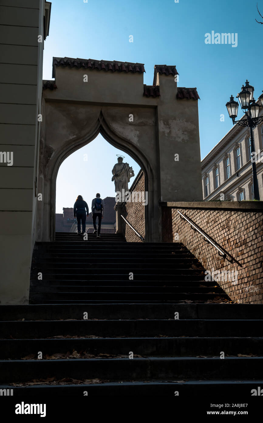 Couple Ascending Steep Stairs With Old Statue In Brno In The Czech Republic Stock Photo