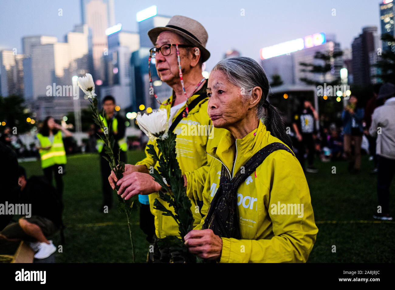 Hong Kong, China. 9th Nov, 2019. A senior couple offer flowers during a memorial rally at Tamar Park in Hong Kong to mourn the death of a 22 years old university student Alex Chow Tsz Lok, who died from a serious brain injury during a fall on November 4th as police skirmished with demonstrators last weekend. He was left in critical condition and died after suffering a cardiac arrest on Friday. Credit: Keith Tsuji/ZUMA Wire/Alamy Live News Stock Photo