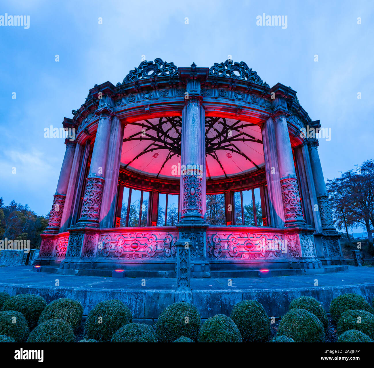 Ruined Victorian orangery lit up red for Scottish Poppy appeal, Dalkeith Country Park, Midlothian, Scotland, UK Stock Photo