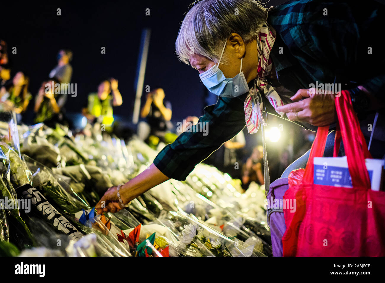 Hong Kong, China. 9th Nov, 2019. A senior woman offers flower during a memorial rally at Tamar Park in Hong Kong to mourn the death of a 22 years old university student Alex Chow Tsz Lok, who died from a serious brain injury during a fall on November 4th as police skirmished with demonstrators last weekend. He was left in critical condition and died after suffering a cardiac arrest on Friday. Credit: Keith Tsuji/ZUMA Wire/Alamy Live News Stock Photo