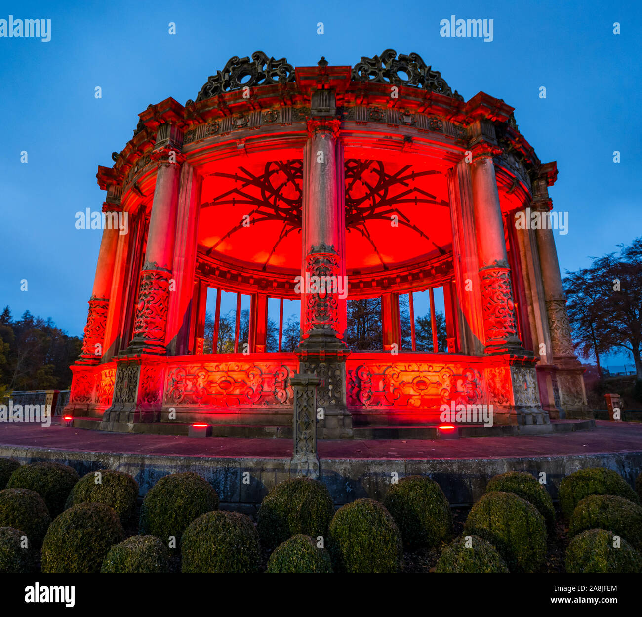 Ruined Victorian orangery lit up red for Scottish Poppy appeal, Dalkeith Country Park, Midlothian, Scotland, UK Stock Photo