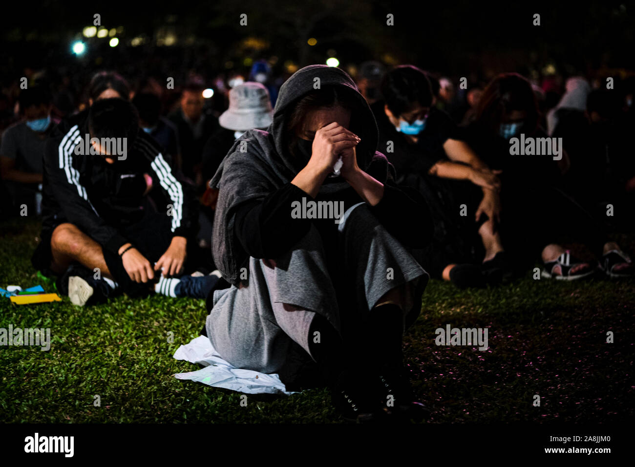 A woman in grief during the rally.Memorial rally at Tamar Park in Hong Kong to mourn the death of a 22 years old university student, Alex Chow Tsz Lok who died from a serious brain injury during a fall on November 4th as police skirmished with demonstrators last weekend. He was left in critical condition and died after suffering a cardiac arrest. Stock Photo