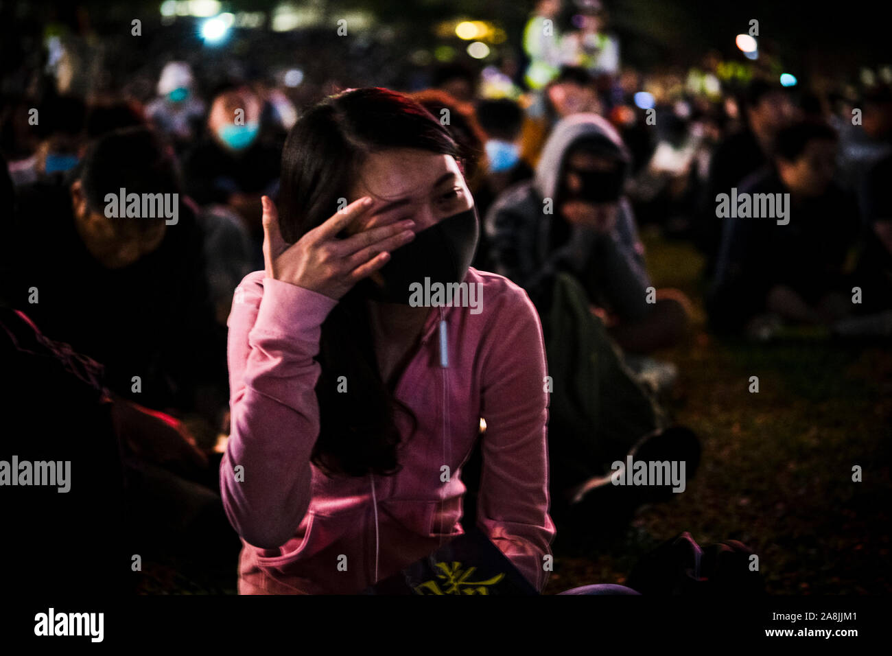 A woman in grief during the rally.Memorial rally at Tamar Park in Hong Kong to mourn the death of a 22 years old university student, Alex Chow Tsz Lok who died from a serious brain injury during a fall on November 4th as police skirmished with demonstrators last weekend. He was left in critical condition and died after suffering a cardiac arrest. Stock Photo