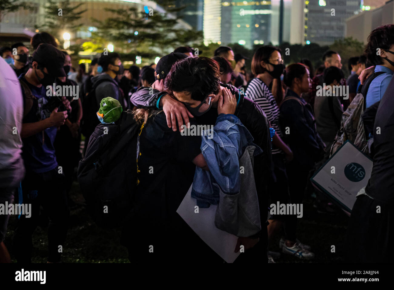 Demonstrators hug each other during the rally.Memorial rally at Tamar Park in Hong Kong to mourn the death of a 22 years old university student, Alex Chow Tsz Lok who died from a serious brain injury during a fall on November 4th as police skirmished with demonstrators last weekend. He was left in critical condition and died after suffering a cardiac arrest. Stock Photo