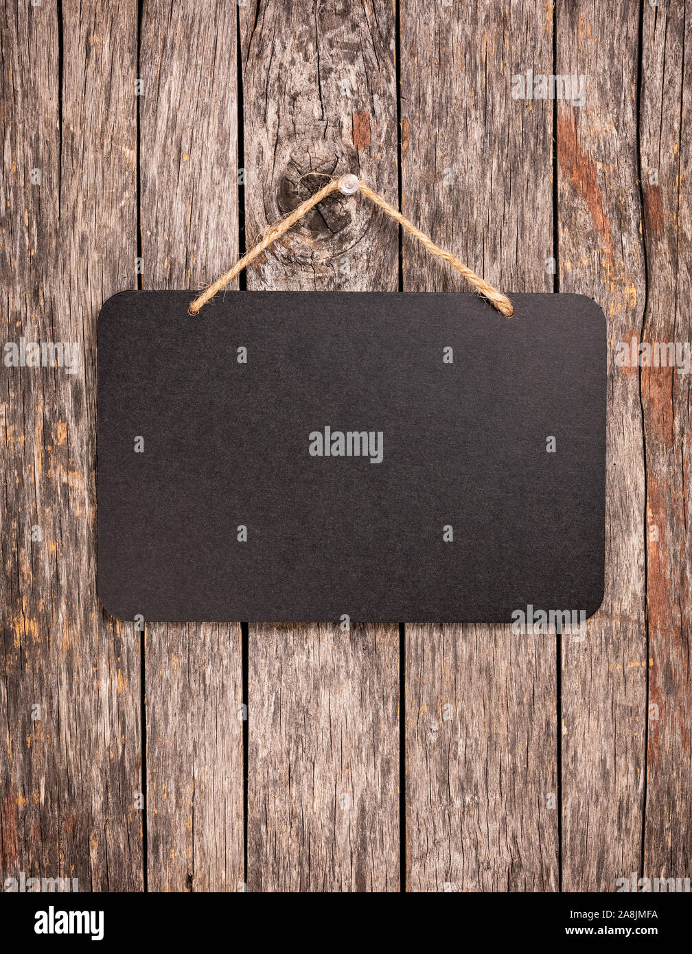 Blank chalkboard sign hanging from old wooden background Stock Photo