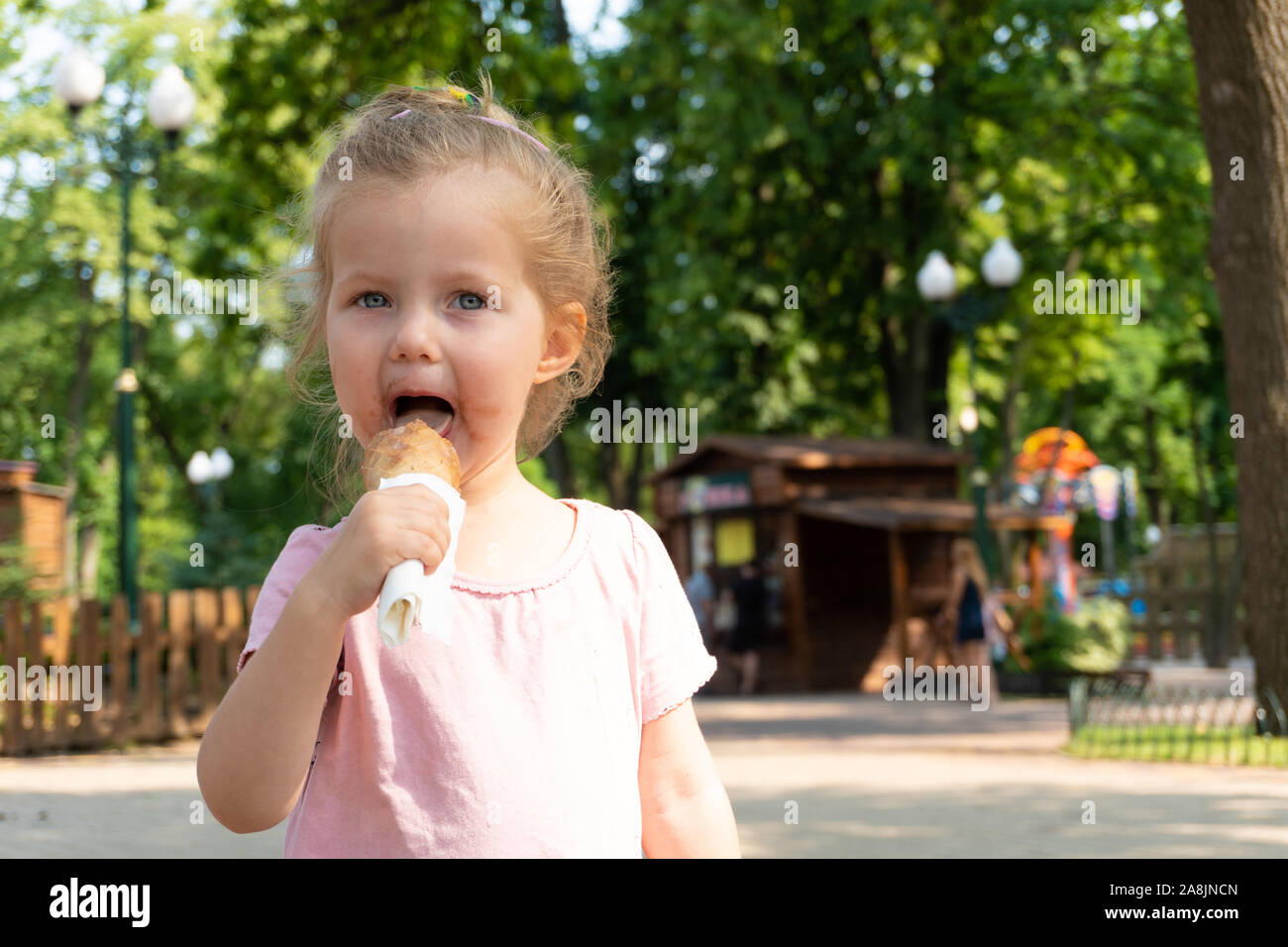 Girl kid eating an ice cream in the park Stock Photo