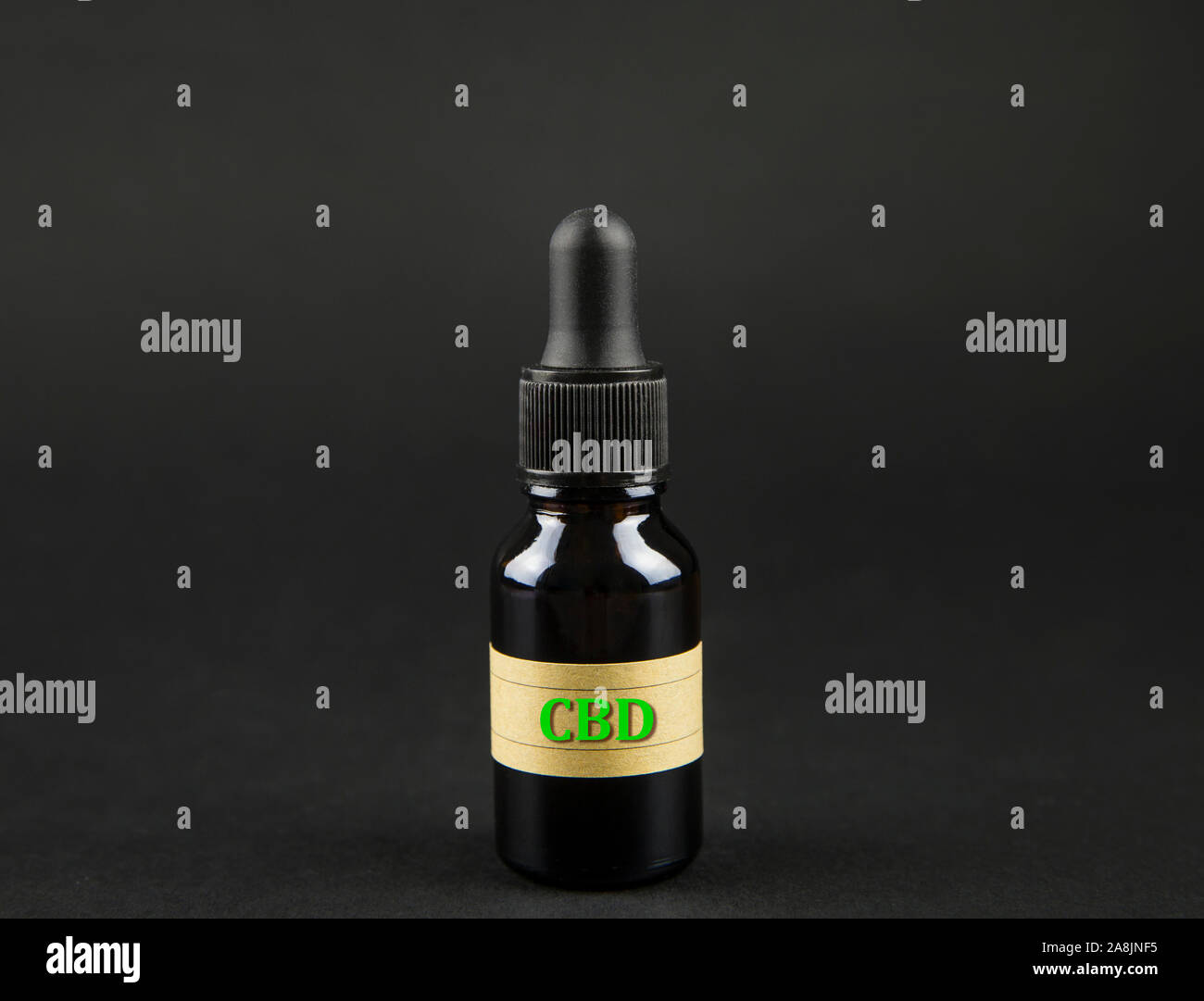 Multipurpose cannabidiol CBD oil concept. Infusion in brown dropper bottle on dark black background. Stock Photo
