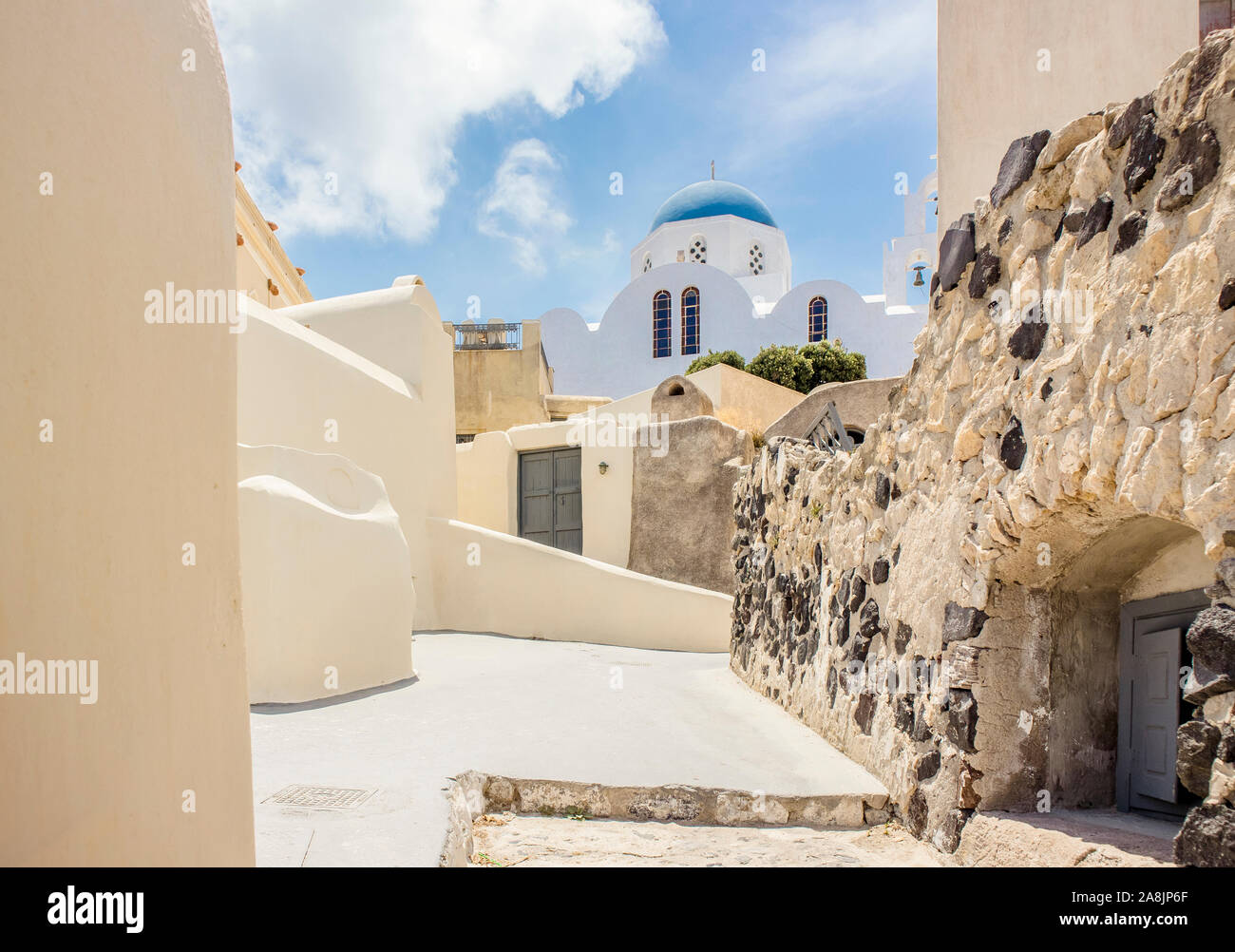 Street view of village Pyrgos and blue dome church on island of Santorini, Greece in Europe. Stock Photo