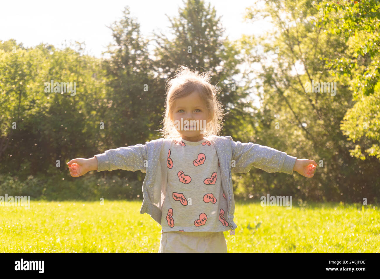Little kid girl enjoy summer sunny day in the park Stock Photo - Alamy