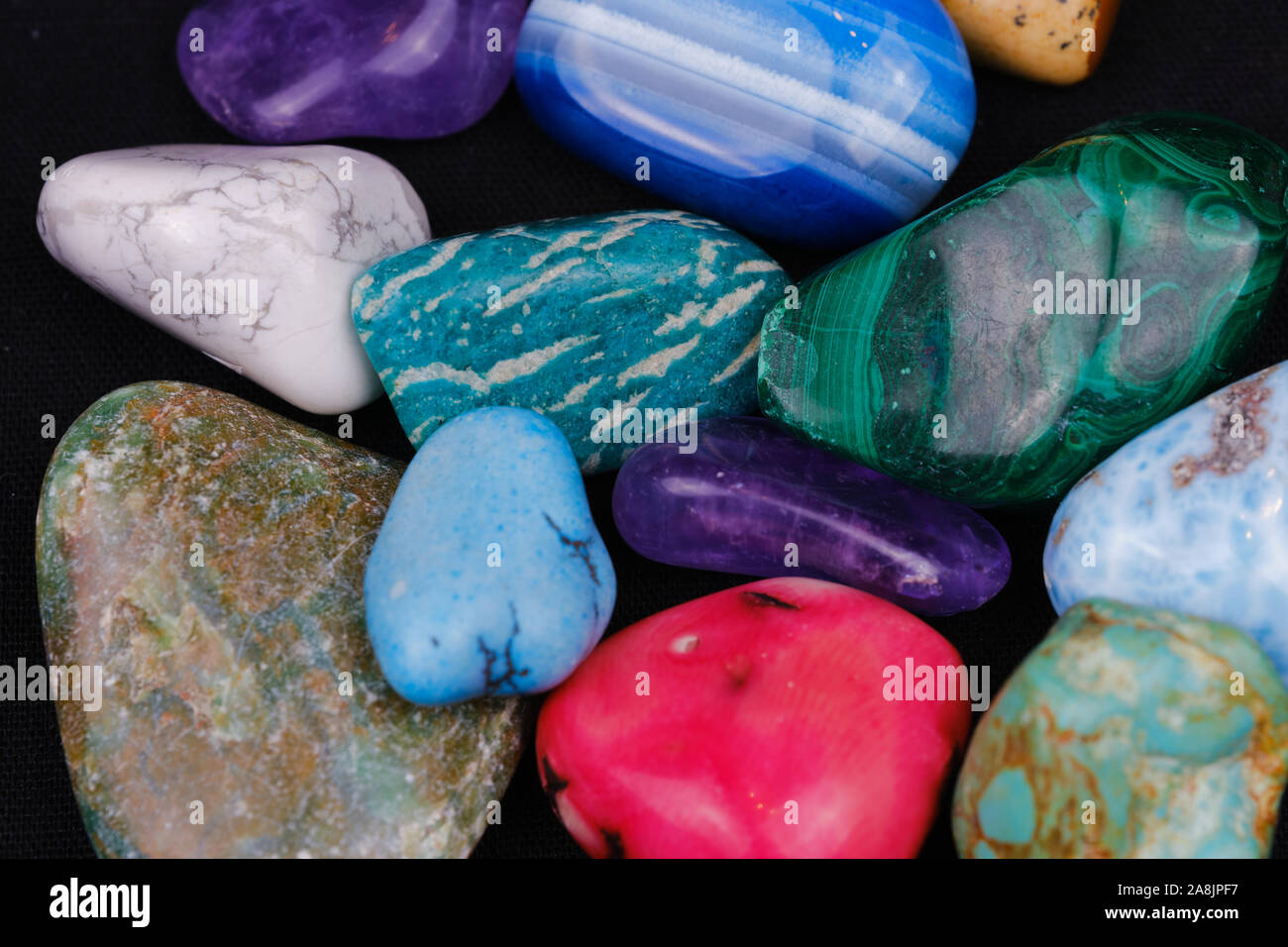 a variety of gemstones on a black surface as background picture Stock Photo