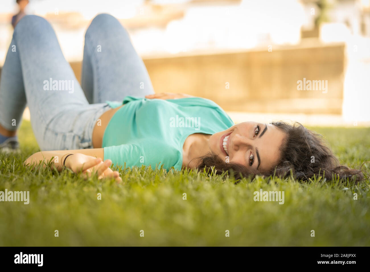 Photographer girl lying on the grass happy and smiling, relaxing Stock Photo