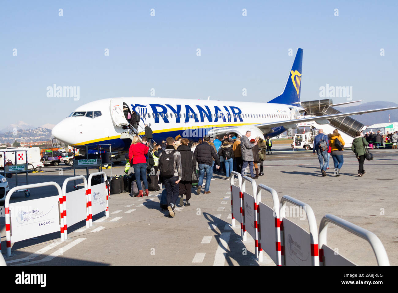 A Ryanair Boeing 737-800 aircraft parked at the Milano Bergamo airport. People are boarding the plane. Stock Photo