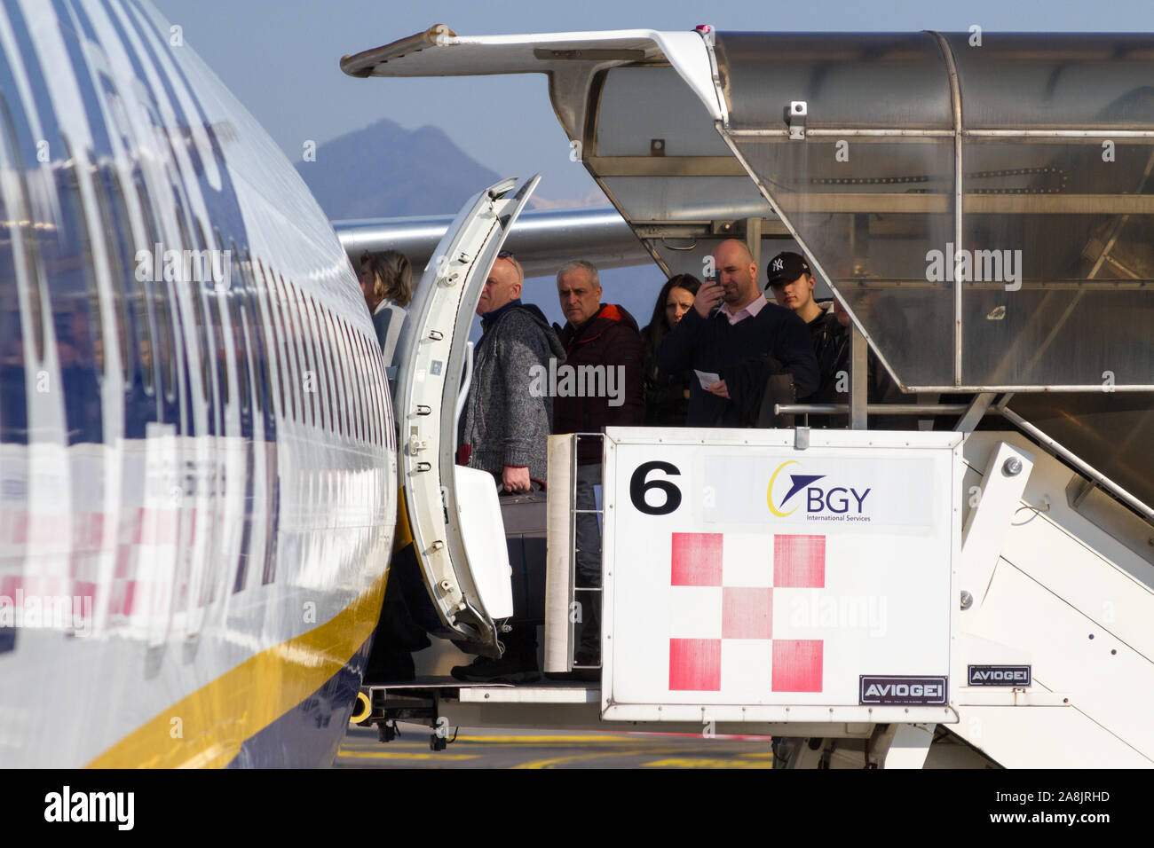 A Ryanair Boeing 737-800 aircraft parked at the Milano Bergamo airport. People are boarding the plane. Stock Photo