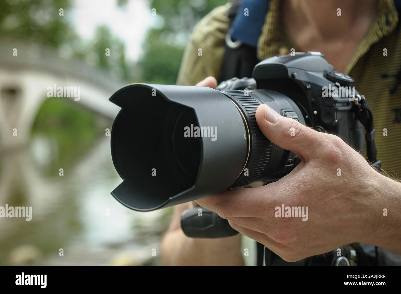The photographer is focusing. The photographer's hand is turning the