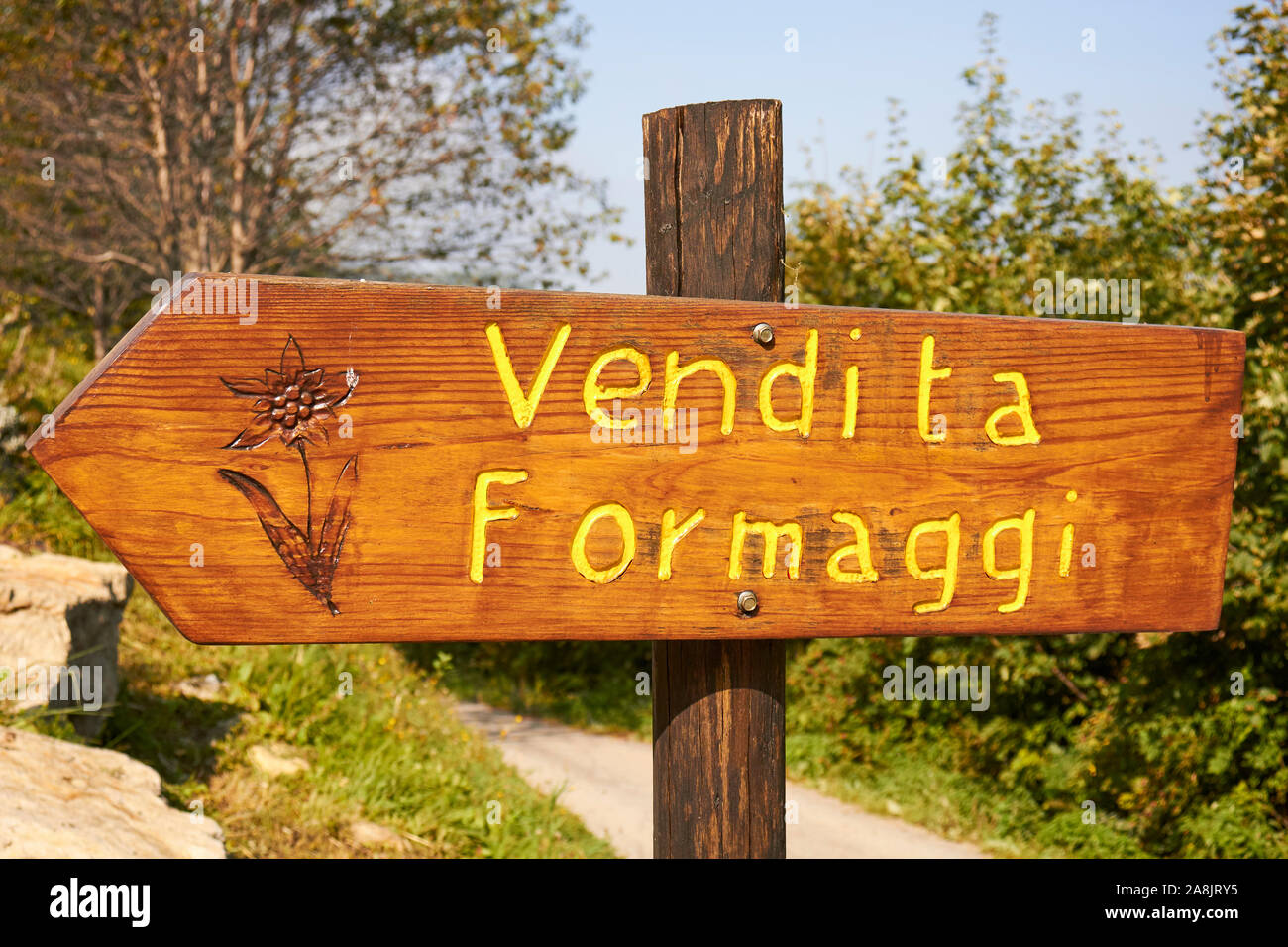A sign reading vendita formaggi or 'cheese sales' in English points to a farm dairy near Cuneo, Piemonte, Italy Stock Photo