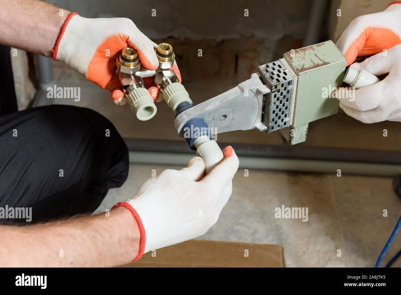 The worker is soldering plastic pipes with HPiece valve for home heating system Stock Photo Alamy