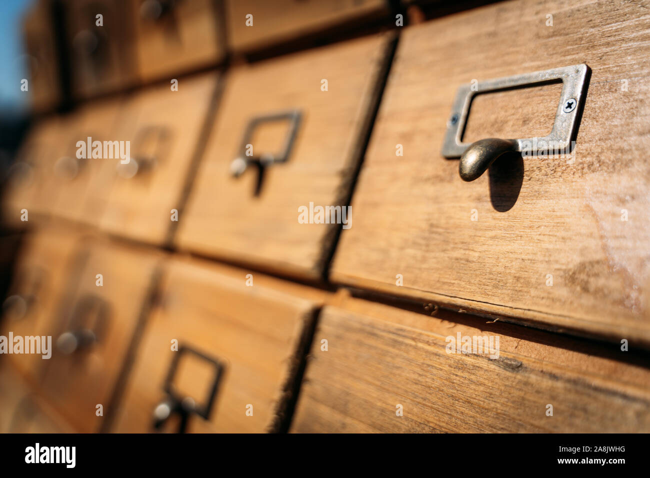 Ancient and lined massive wood file cabinets with blur background and focus en one of them. Concept of organization Stock Photo