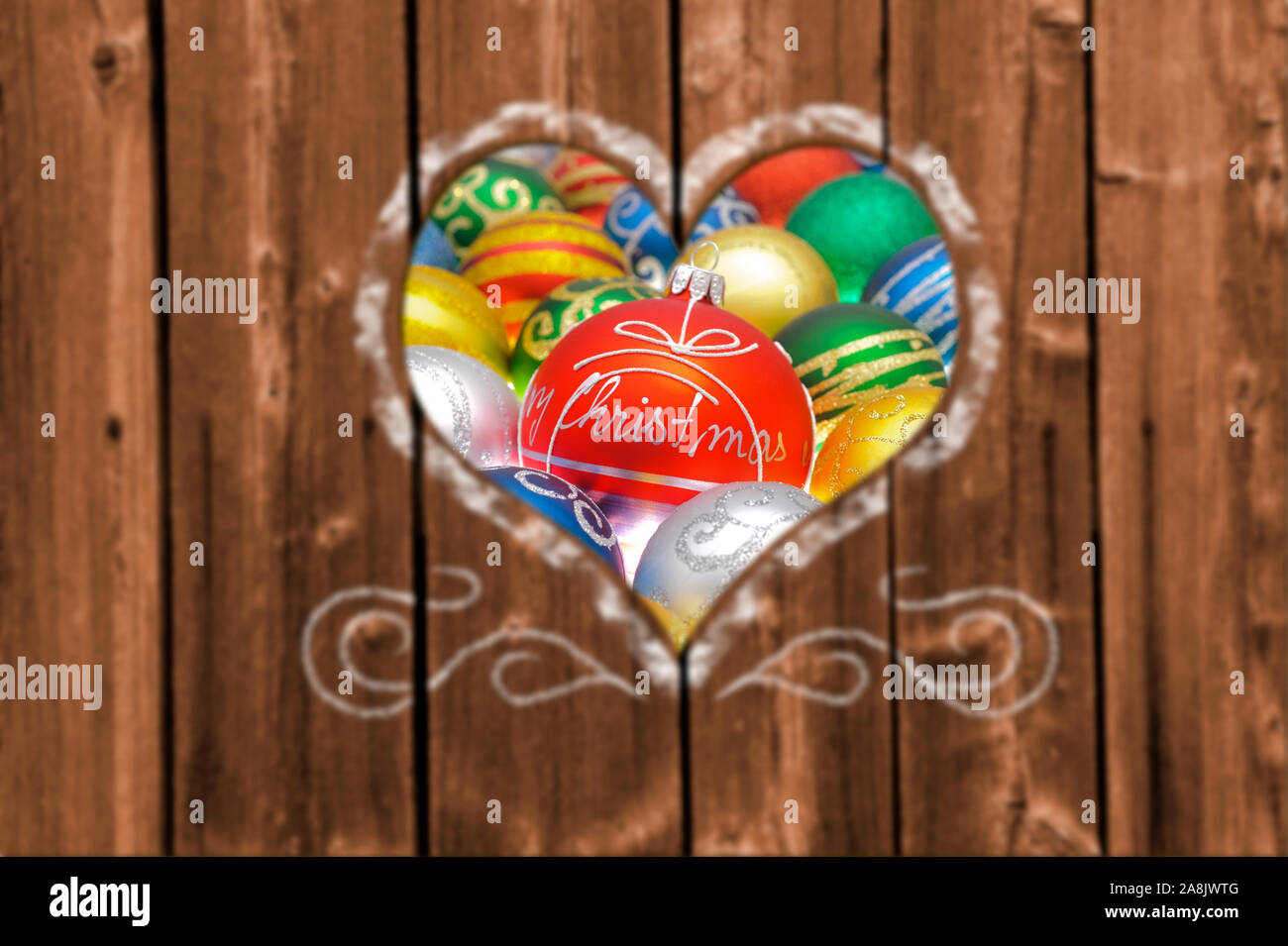 Looking through a carved heart in a wooden wall to christmas decoration Stock Photo