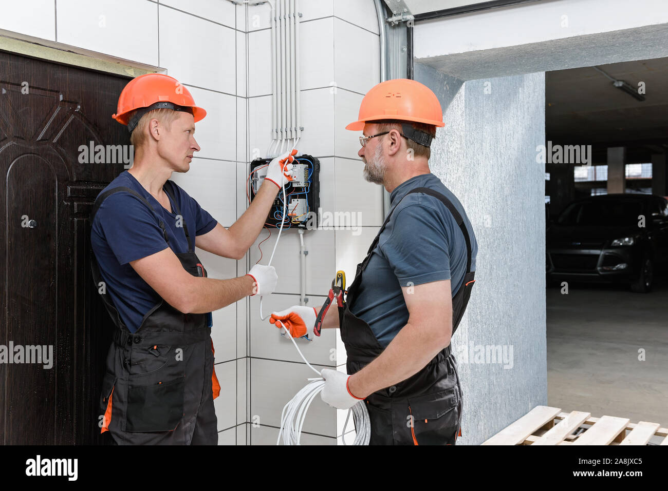 Electricians are installing out wall wiring. They are pulling the wires