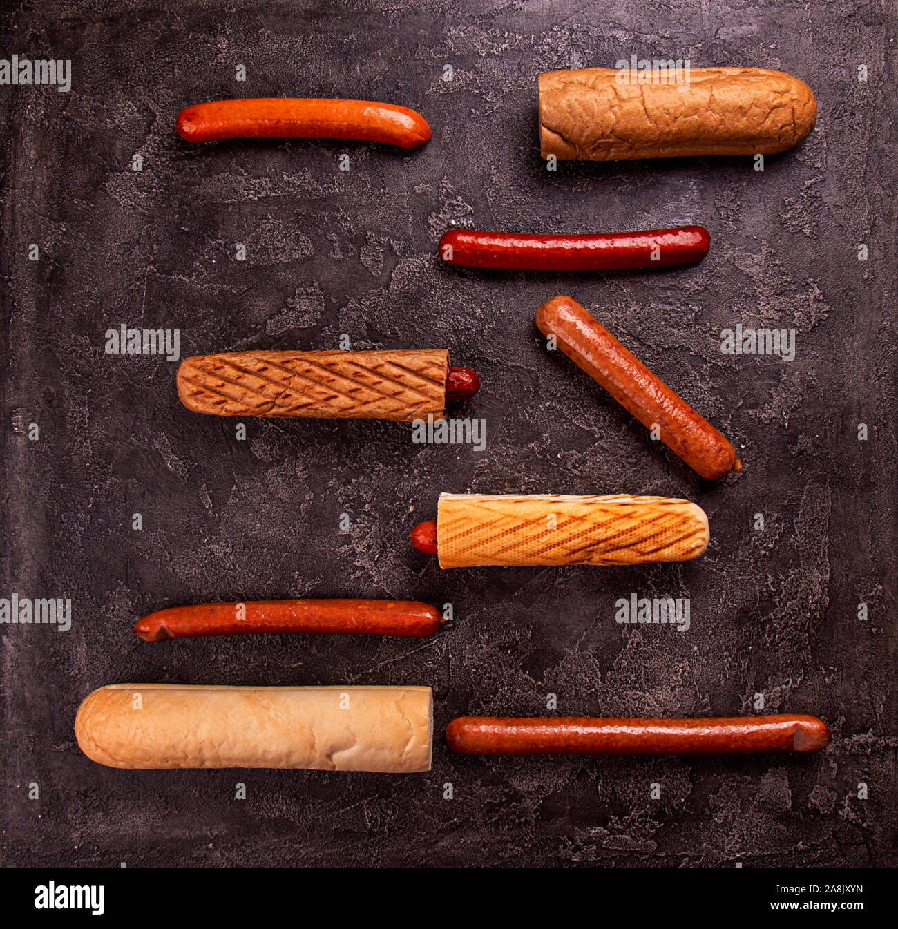 Ingrdients for hot dogs buns various sausages on black concrete background. copy space, top view Stock Photo