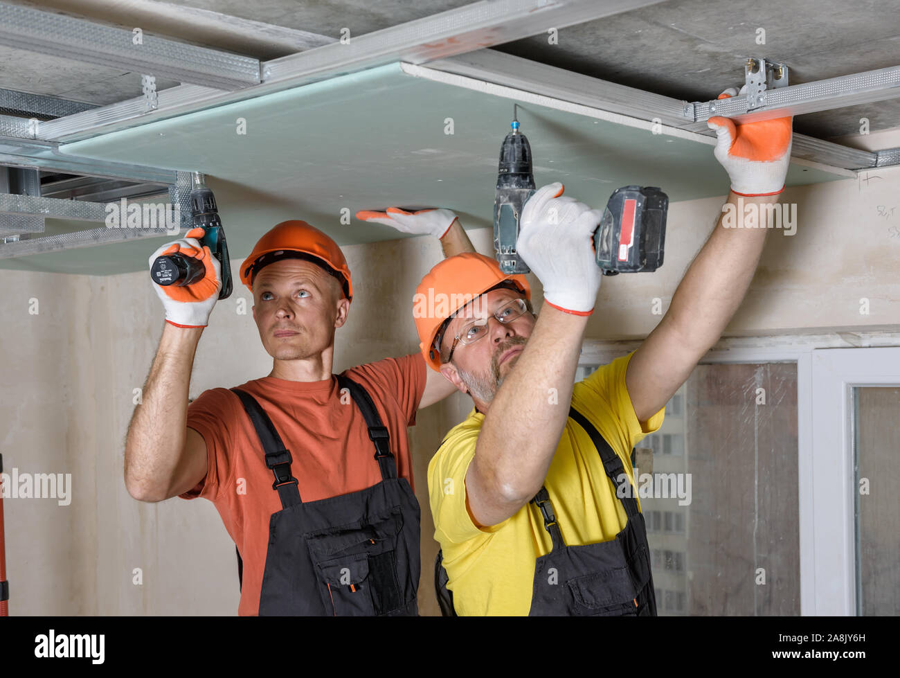 Workers Are Using Screwdrivers To Installing Plasterboard To