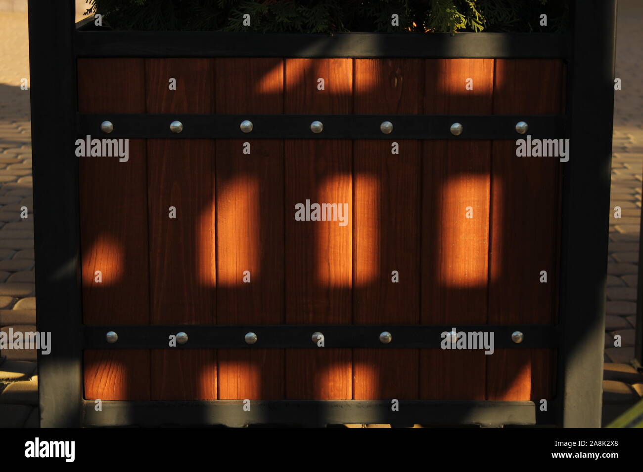 This is a wooden brown box with a metal frame in my yard, which is lit by the evening sun. Stock Photo
