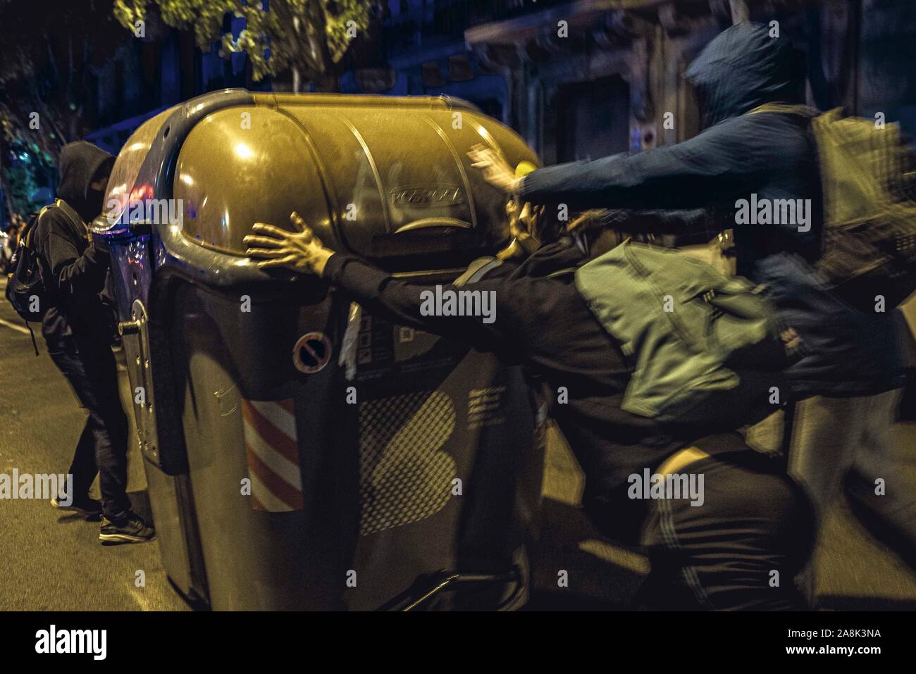Barcelona, Spain. 9 November, 2019:  Members of Barcelona's CDR (Committee for the Defense of the Republic) build barricades moving garbage containers protesting the Supreme Court's verdict against 9 Catalan leaders over their role in a banned referendum on secession in October 2017 as an act of civil disobedience against the central electoral commission during election silence the day before a general election. Stock Photo