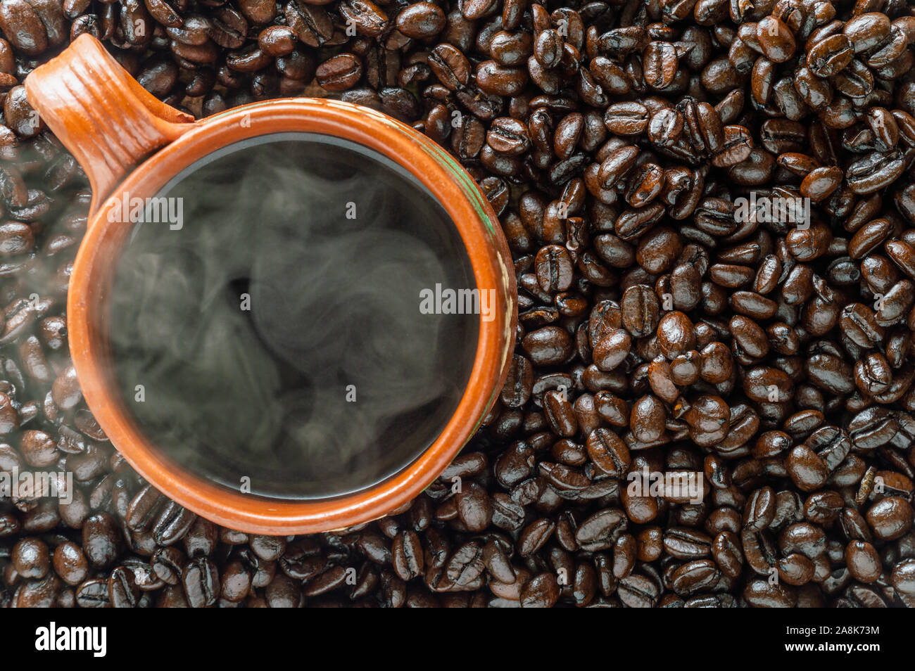 Steaming mug of Mexican coffee and dark roasted coffee beans. Background or use for menus, pages
