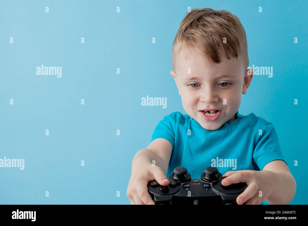 Little kid boy 2-3 years old wearing blue clothes hold in hand joystick ...