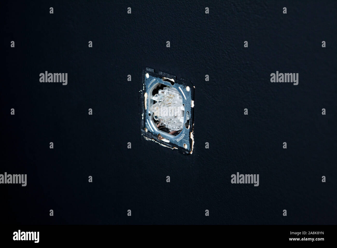 Double white light switches on a black wall background. Horizontal. Stock Photo