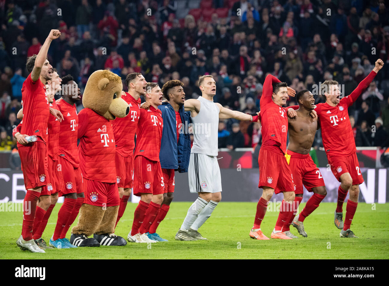 09 November 2019, Bavaria, Munich: Soccer: Bundesliga, Bayern Munich - Borussia Dortmund, 11th matchday in the Allianz Arena. The FC Bayern Munich players celebrate their victory with the fans after the match. Javi Martinez (l-r), Philippe Coutinho, Benjamin Pavard, Alphonso Davies, mascot Berni, Leon Goretzka, Joshua Kimmich, Kingsley Coman, goalkeeper Manuel Neuer, Robert Lewandowski, David Alaba and Thomas Müller. Photo: Matthias Balk/dpa - IMPORTANT NOTE: In accordance with the requirements of the DFL Deutsche Fußball Liga or the DFB Deutscher Fußball-Bund, it is prohibited to use or have Stock Photo
