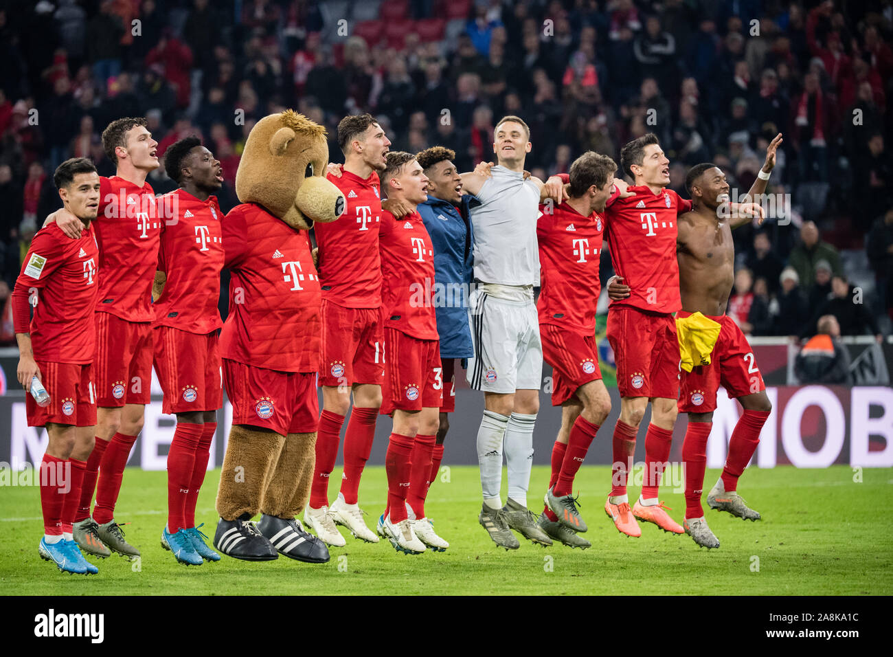 09 November 2019, Bavaria, Munich: Soccer: Bundesliga, Bayern Munich - Borussia Dortmund, 11th matchday in the Allianz Arena. The FC Bayern Munich players celebrate their victory with the fans after the match. Philippe Coutinho (l-r), Benjamin Pavard, Alphonso Davies, mascot Berni, Leon Goretzka, Joshua Kimmich, Kingsley Coman, goalkeeper Manuel Neuer, Robert Lewandowski, David Alaba and Thomas Müller. Photo: Matthias Balk/dpa - IMPORTANT NOTE: In accordance with the requirements of the DFL Deutsche Fußball Liga or the DFB Deutscher Fußball-Bund, it is prohibited to use or have used photograph Stock Photo