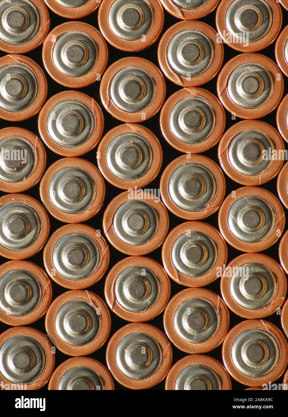 Background wallpaper of columns of batteries positive side up. Multiple batteries stacked together to form an organized vertical pattern. Stock Photo