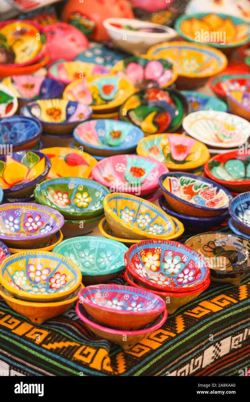 A table full of handmade painted bowls for sale in an outdoor market in a tourist market in Mexico Stock Photo