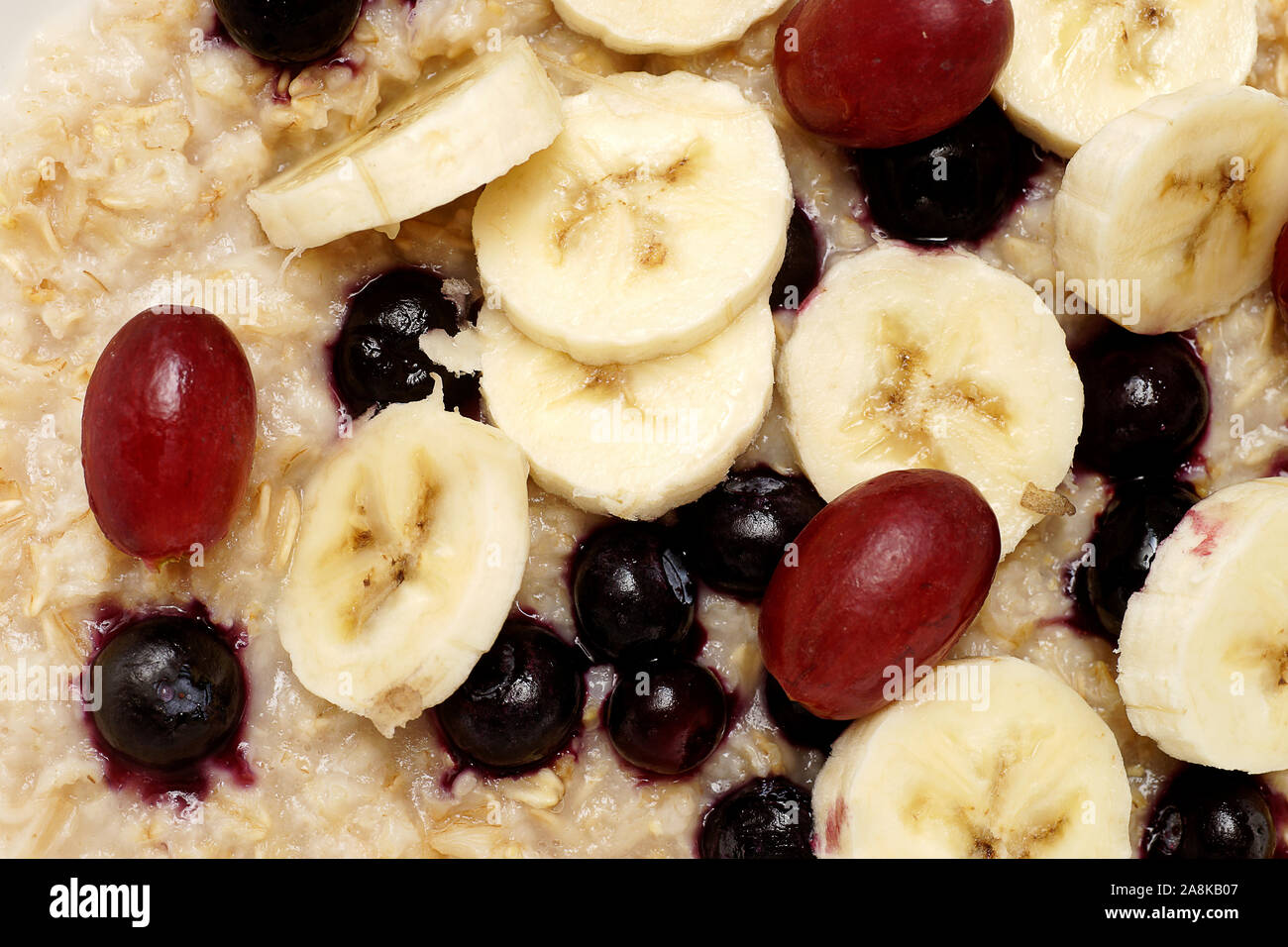 Oatmeal Breakfast With Bananas Blueberries And Red Grapes Isolated On White Background And Photographed From Directly Above Stock Photo Alamy