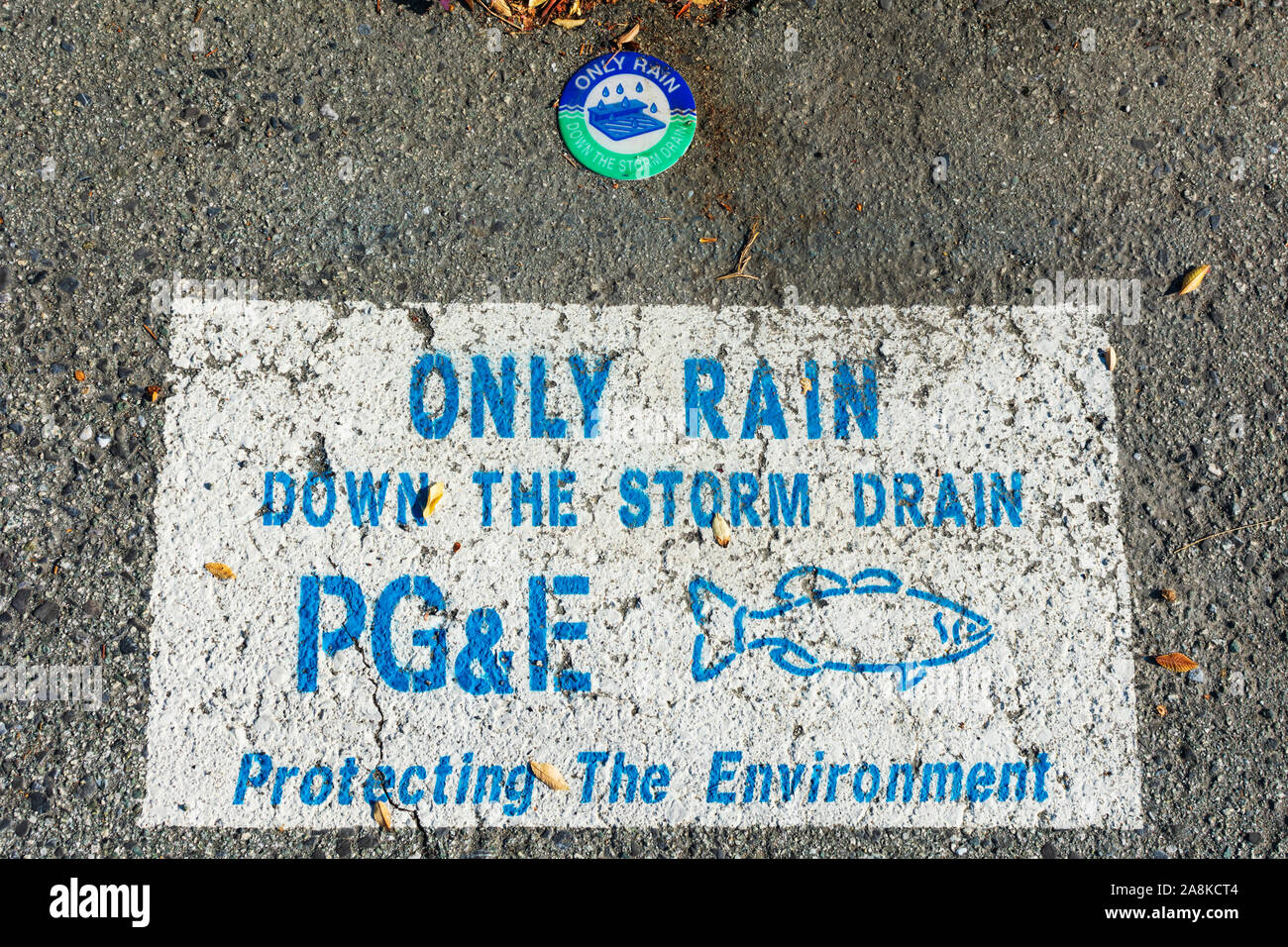 Only rain down to storm drain warning sign PG&E,Pacific Gas and Electric Company, near street drain inlet. Fish Silhouette. Protecting the environment Stock Photo