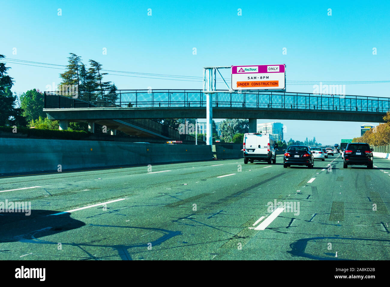 Palo Alto, California, USA - November, 2019 : Light traffic on divided highway 101. Pedestrian bridge over road. FasTrak  overhead signage informing d Stock Photo