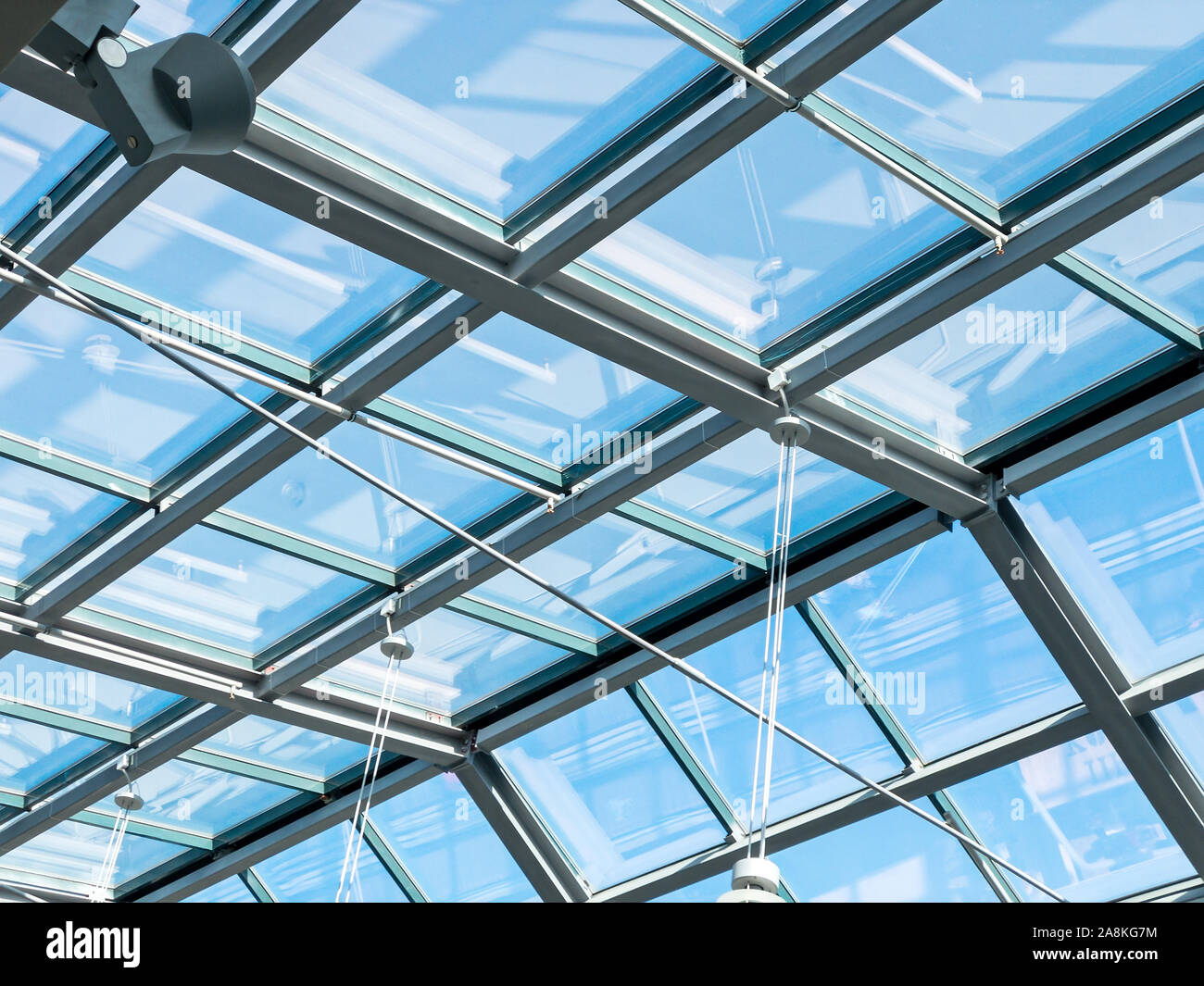 closeup inside view of modern transparent glass roof. blue sky through a glass ceiling Stock Photo